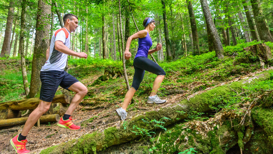 Frau und Mann joggen im Wald