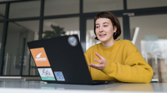 Studentin interagiert mit Medium am Laptopbildschirm