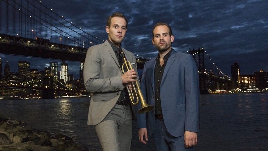 Die Brüder und Musiker Julian und Roman Wasserfuhr stehen vor einer Brücke.