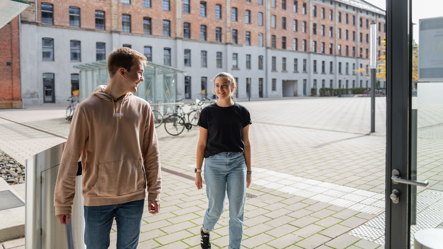 Tobias und Theresa betreten das Gebäude "An der WebACerei" 5