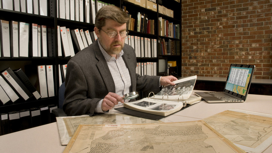 Ein Wissenschaftler bei der Recherchearbeit in historischen Werken.