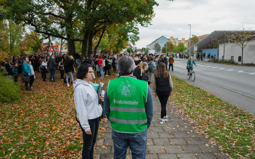 Brandschutzhelferin und Brandschutzhelfer beraten sich.