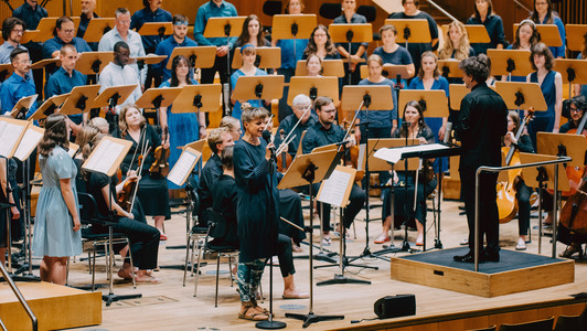 Schauspielerin Meike Hess steht mit dem Orchester auf der Bühne