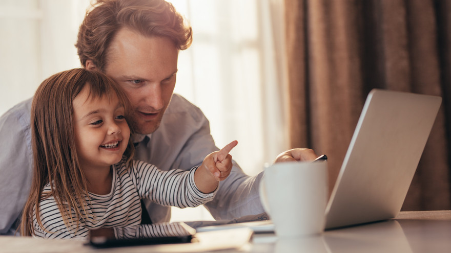 Vater und Tochter sitzen zusammen am Computer