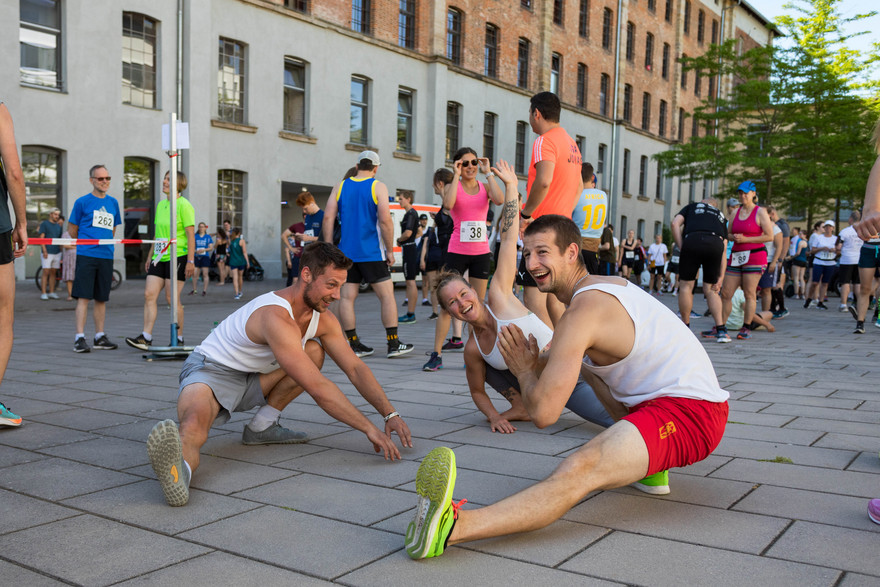 Die Teilnehmer*innen wärmen sich vor dem Uni-Lauf auf - ins Schwitzen kommen sie schon vor dem Startschuss.