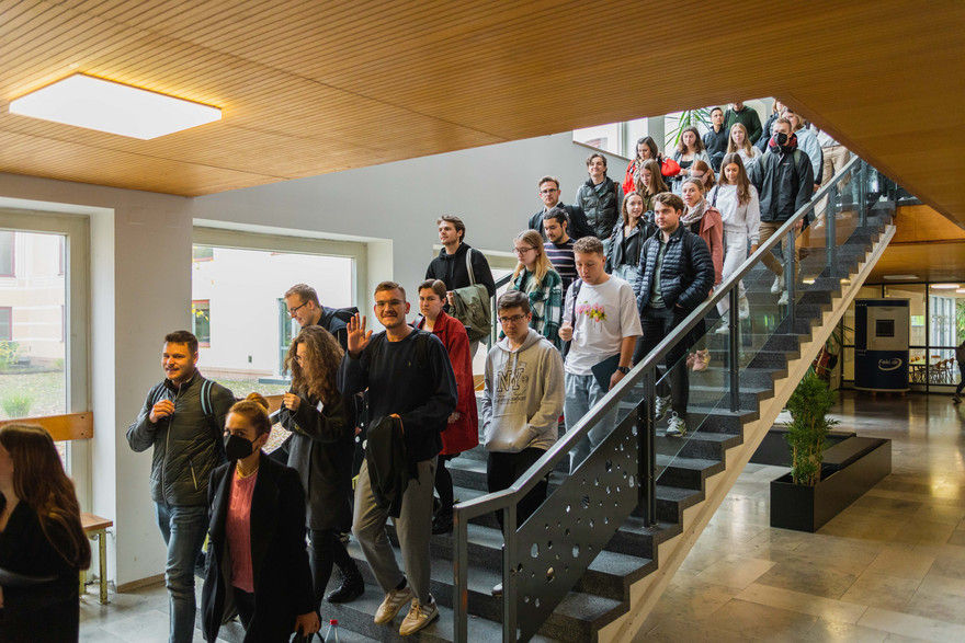 Studierende laufen die Treppe im Gebäude der Feki hinunter.