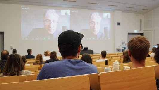 Personen sitzen in einem Hörsaal und hören dem Vortrag zu.