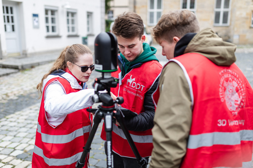 Mona Hess bedient gemeinsam mit Studierenden den Scanner vor dem Gebäude U9.