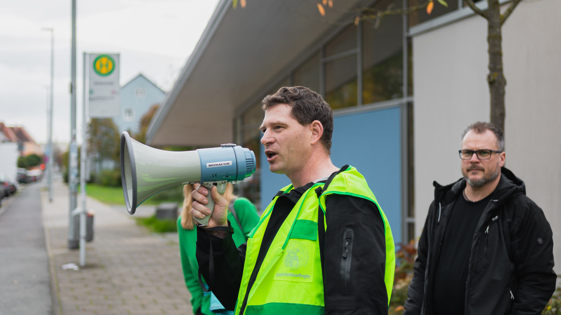 Der Brandschutzbeauftragte Christian Übel hält ein Megaphon in der Hand