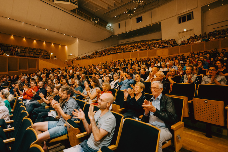 Klatschende Menschen sitzen im Konzertsaal