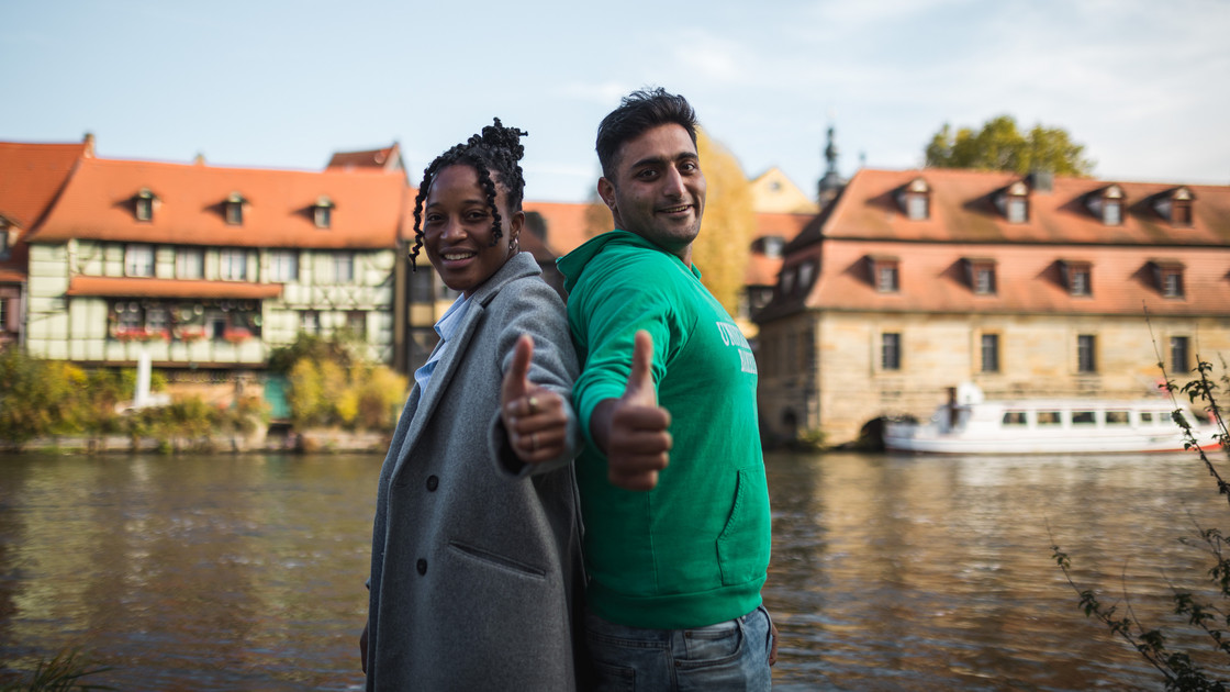 Eine junge Frau und ein junger Mann zeigen den Daumen nach oben.